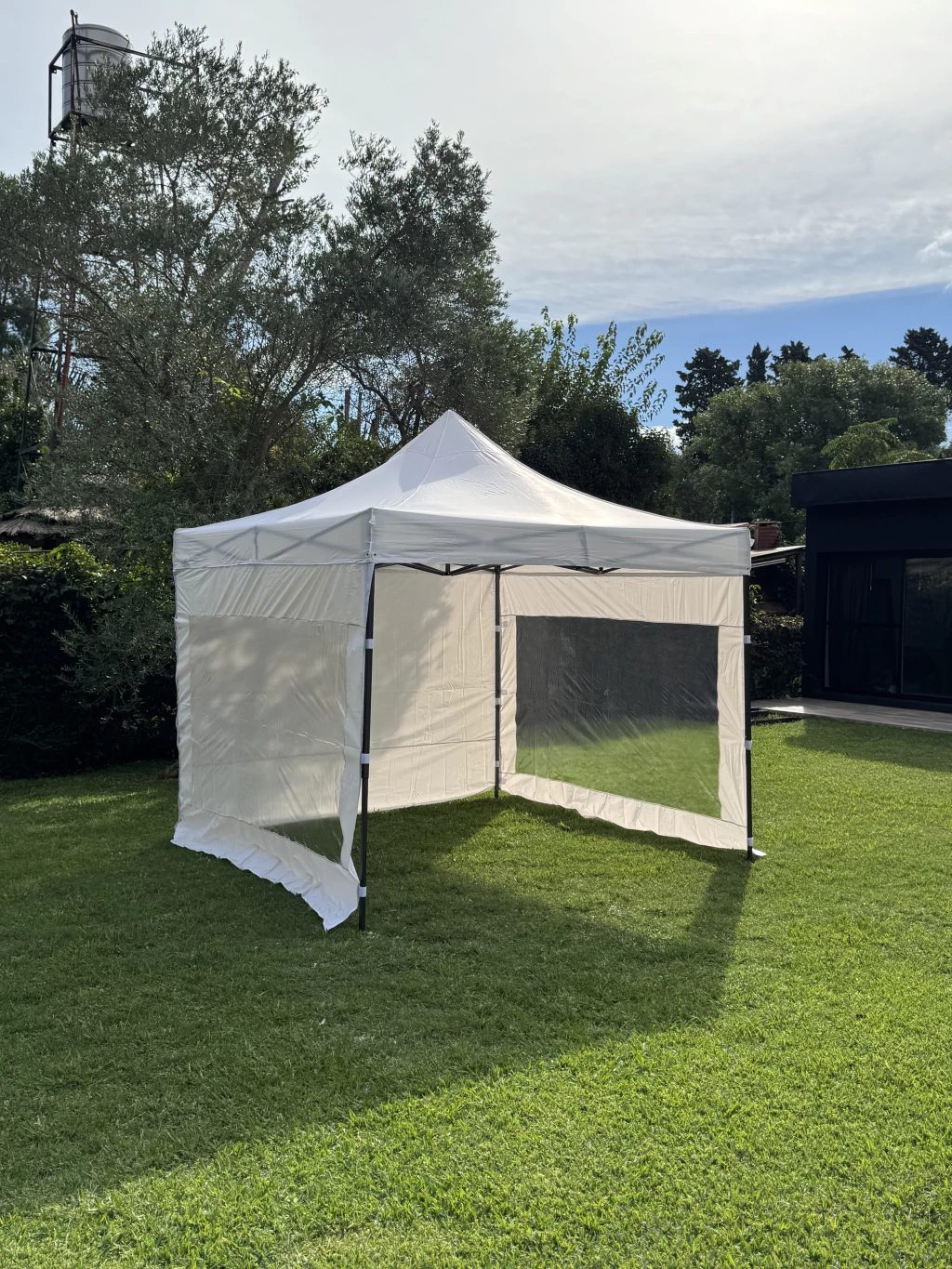Gazebo plegable blanco en jardín familiar